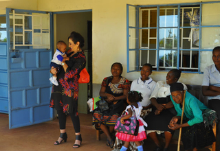 Honorary Ambassador Ms. Gina Din greets a mother and her baby at the Uhiri Health facility during her visit