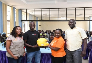 UNFPA staff present a helmet to Boda-Boda Association of Kenya Chair Kevin Mubadi in Kisumu County.
