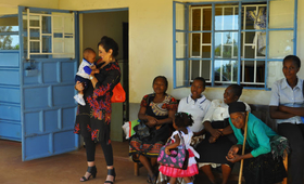 Honorary Ambassador Ms. Gina Din greets a mother and her baby at the Uhiri Health facility during her visit