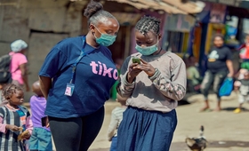 Community mobiliser Joyce Katheu helps a girl enroll on the Tiko platform in Mathare Informal Settlement, Nairobi. Photo: © Trig