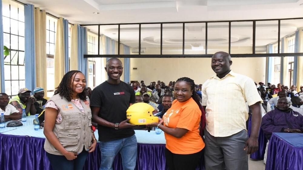 UNFPA staff present a helmet to Boda-Boda Association of Kenya Chair Kevin Mubadi in Kisumu County.